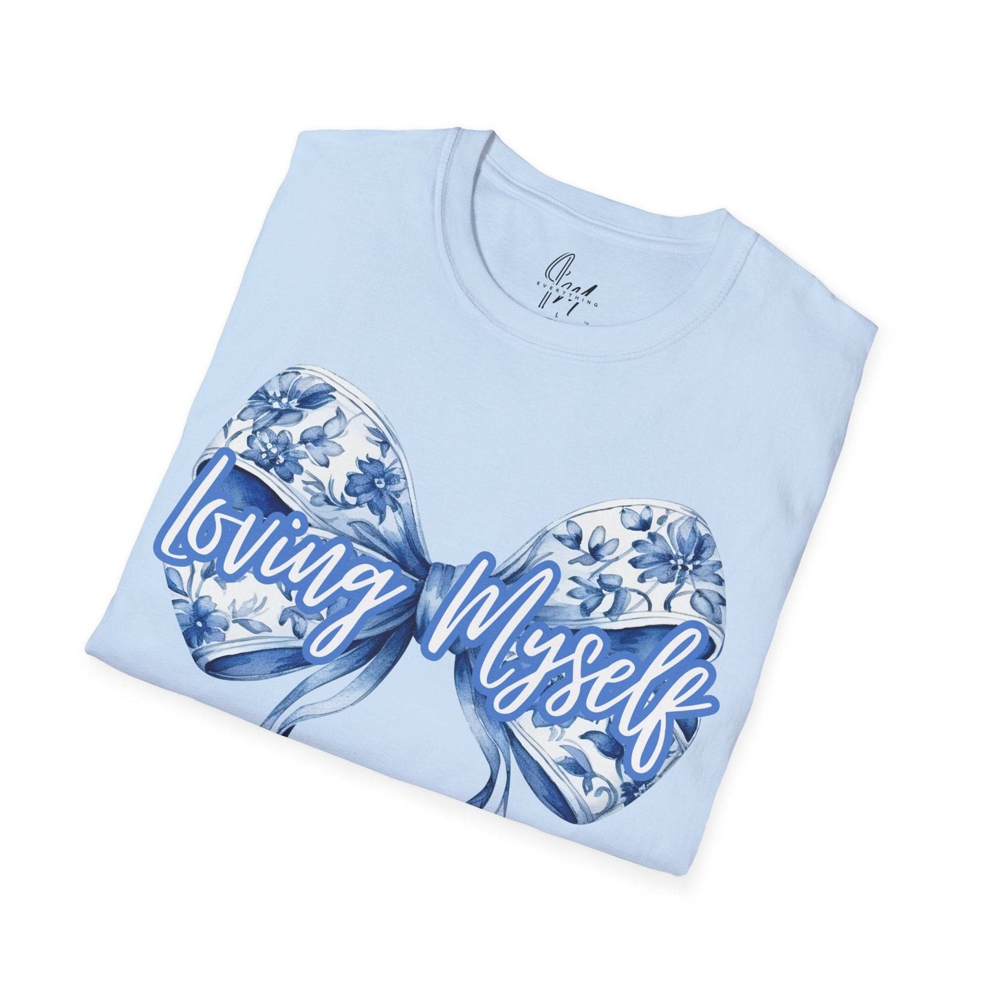 Loving Myself T-shirt in light blue with a floral bow graphic and bold script text, perfect for promoting self love and mental health awareness.